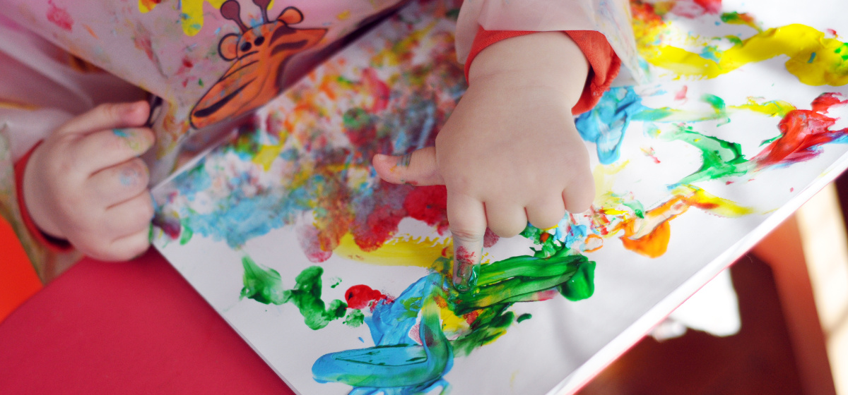 Photo d'un bébé faisant de la peinture sur une toile